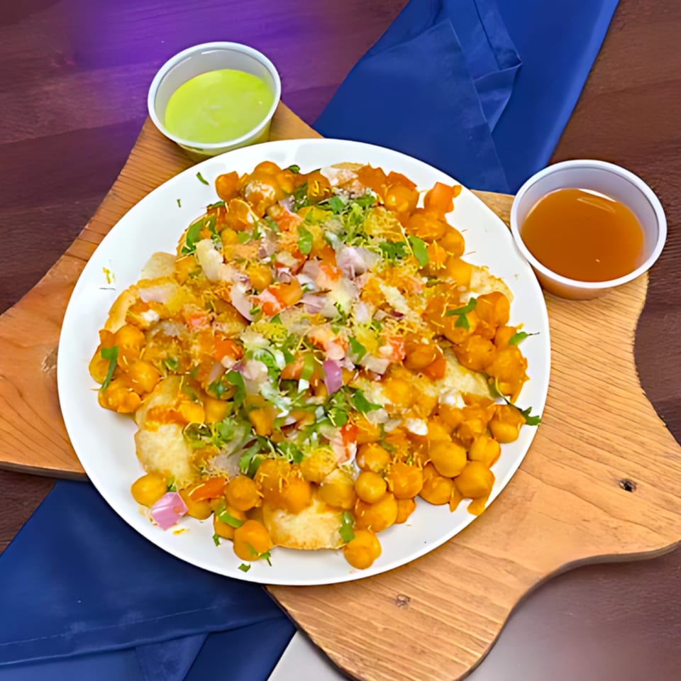 Milagu Indian Cuisine's chaat, a colorful dish with chickpeas, vegetables, and sauces on a white plate.